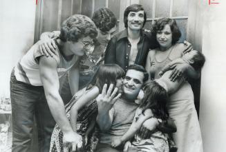 Father of quadruplets, Giuseppe Denardo (seated), 41, is congratulated by family members