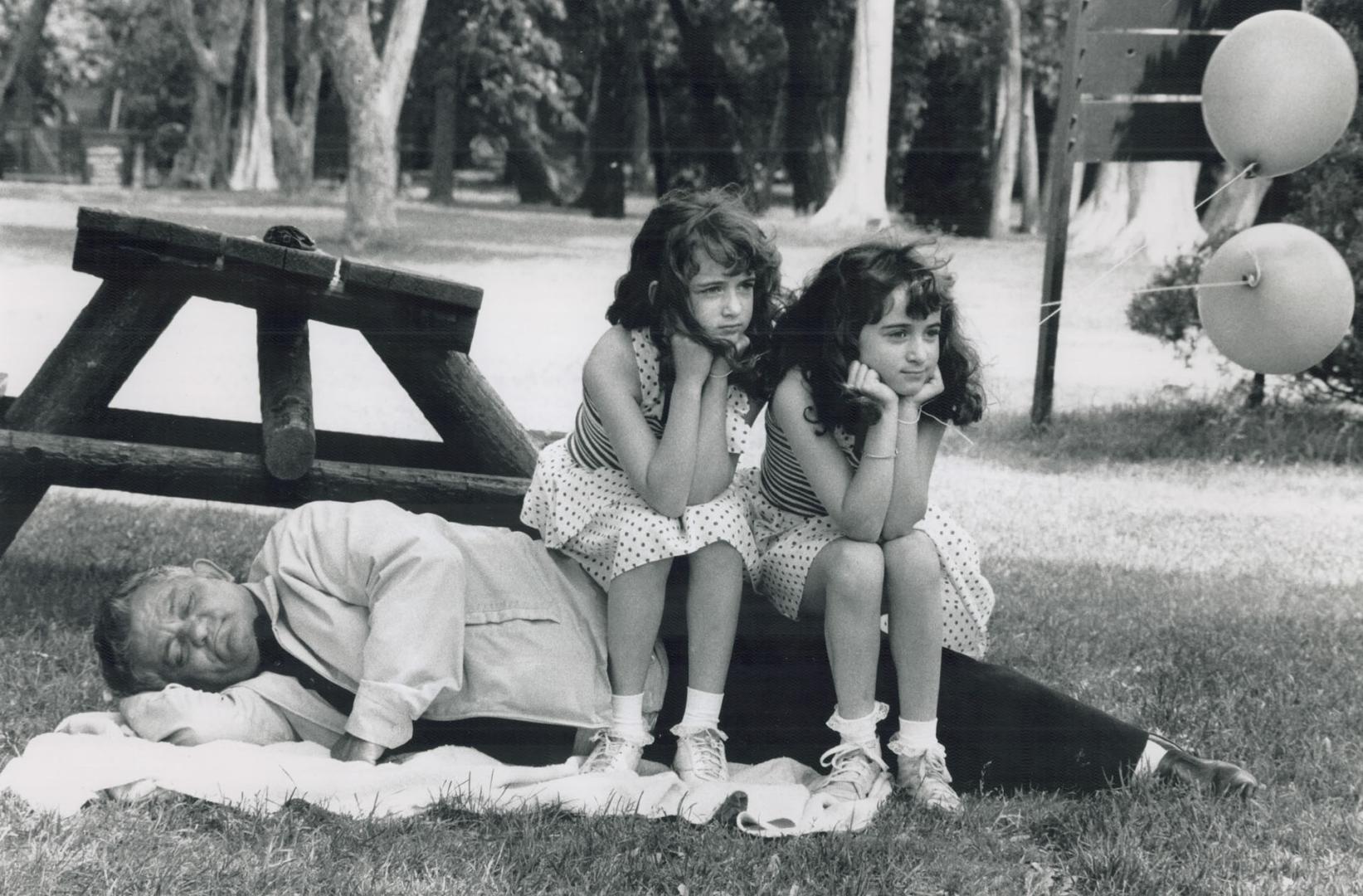 Doubling up on grandpa, While Frank Spensieri takes advantage of the warm summer weather for a snooze, his twin granddaughters Cara, left, and Lori Spensieri take time out for a rest