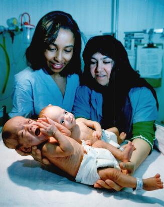 Proud moment: Dr. Tanya Williams, left, and Maryam Noormohammad hold Noormohammad's twins Palvasha, front, and Farishta yesterday