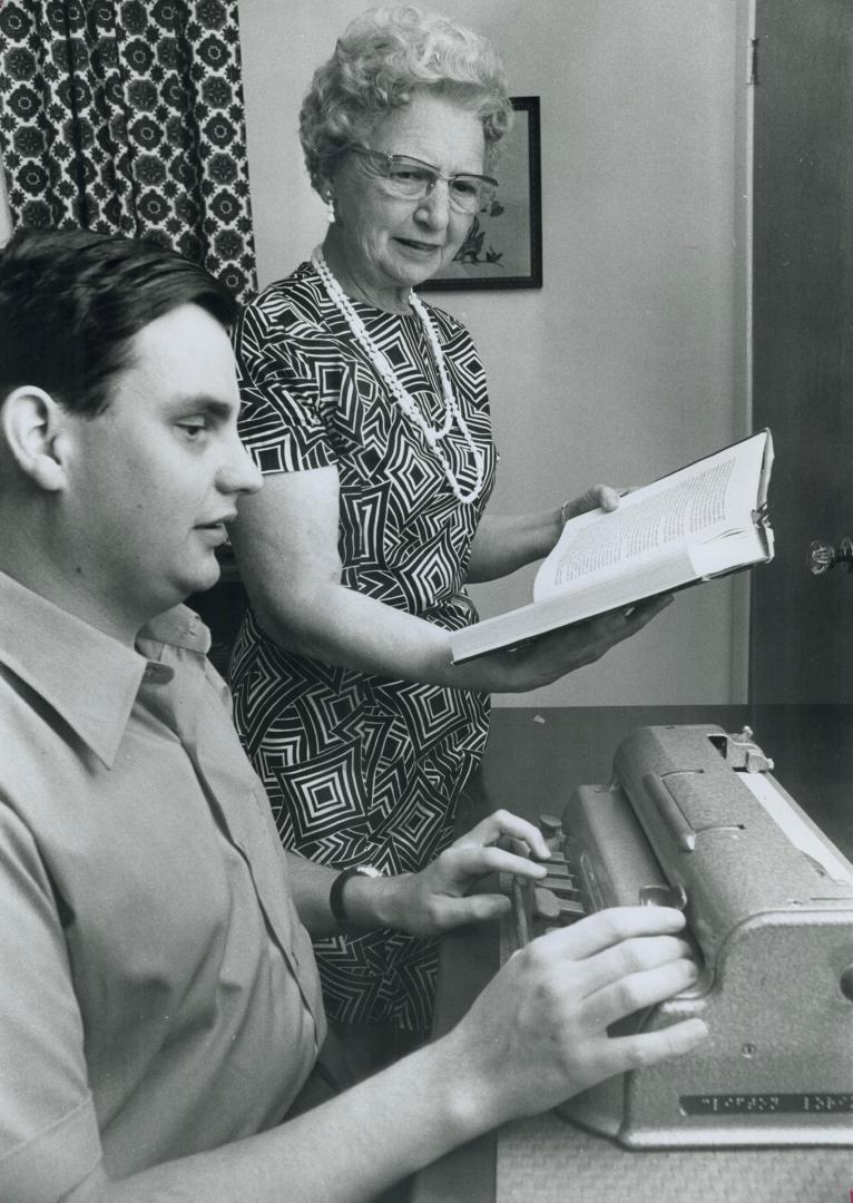 Clinton Lorimer, 20, works at Braille typewriter, He makes notes while his mother Mrs