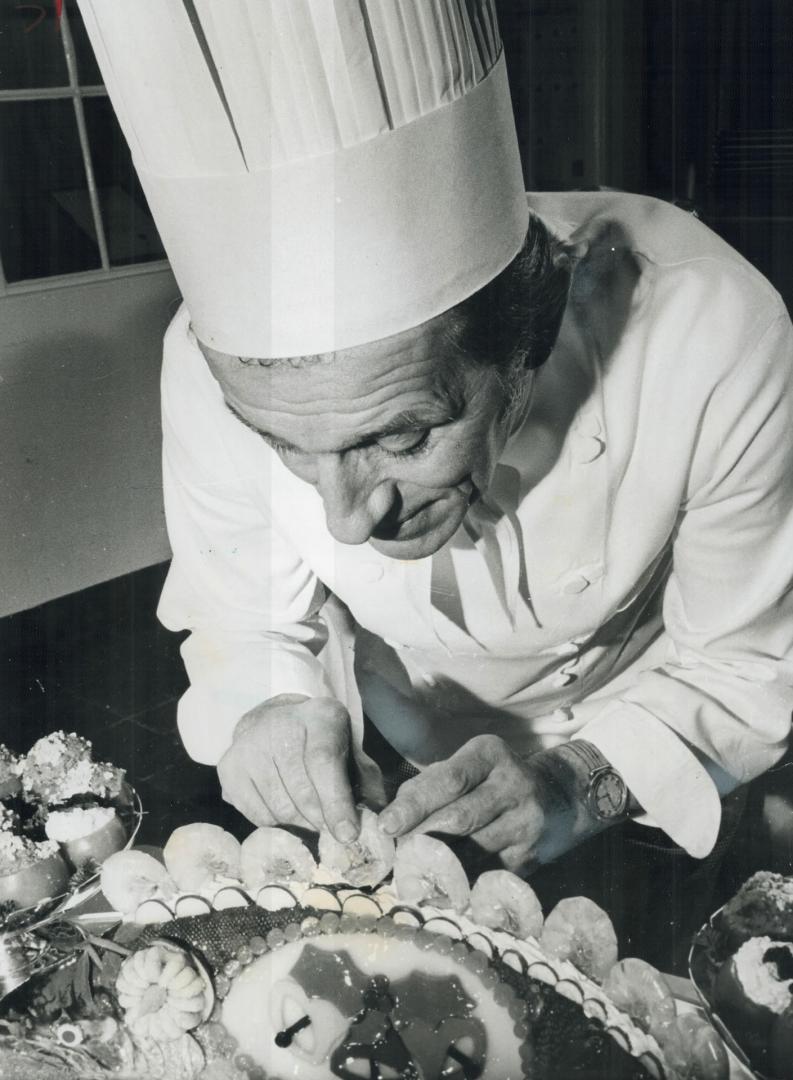 Expecting 1,500 guests for dinner at the Royal York Hotel tomorrow, executive chef Marcel Didier puts finishing touches on a whole, poached salmon for(...)