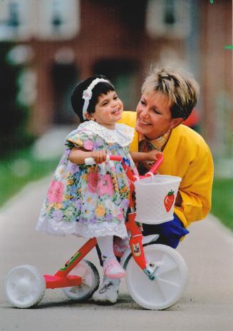 A new little Canadian, Anne Hull plays with her tiny adopted daughter, Alexandra, in Mississauga