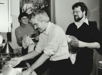 Doing the chores: Father Jean-Marc Laporte, president of the Jesuits' Regis College, washes dishes, while students Alojz Podgrea, left and Thomas Fisk dry