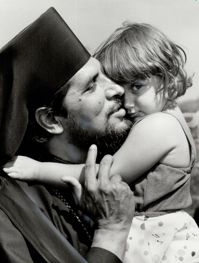 Metropolitan's kiss: Little Elizabeth Andrevska got a big kiss from Metropolitan Kiril Popovski at the annual Macedonian Ilinden picnic in East Gwillimbury township yesterday