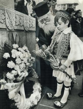 Free. Dimitrios Siafas, 6, places flowers on the Old City Hall cenotaph as Metro' Greek-Macedonians celebrate the liberation of their homeland by Gree(...)