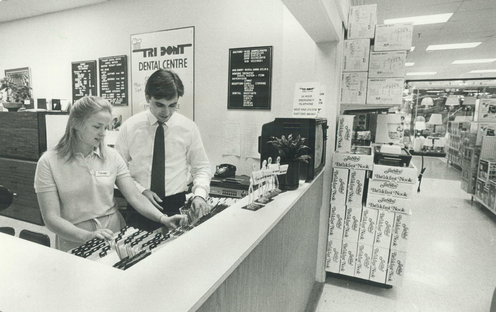 Walk-in dentistry: Dr. John Ohorodnyk and receptionist Deirdre McGarry check files at the Tridont Dental Centre in the Woolco store at Square One, Mis(...)