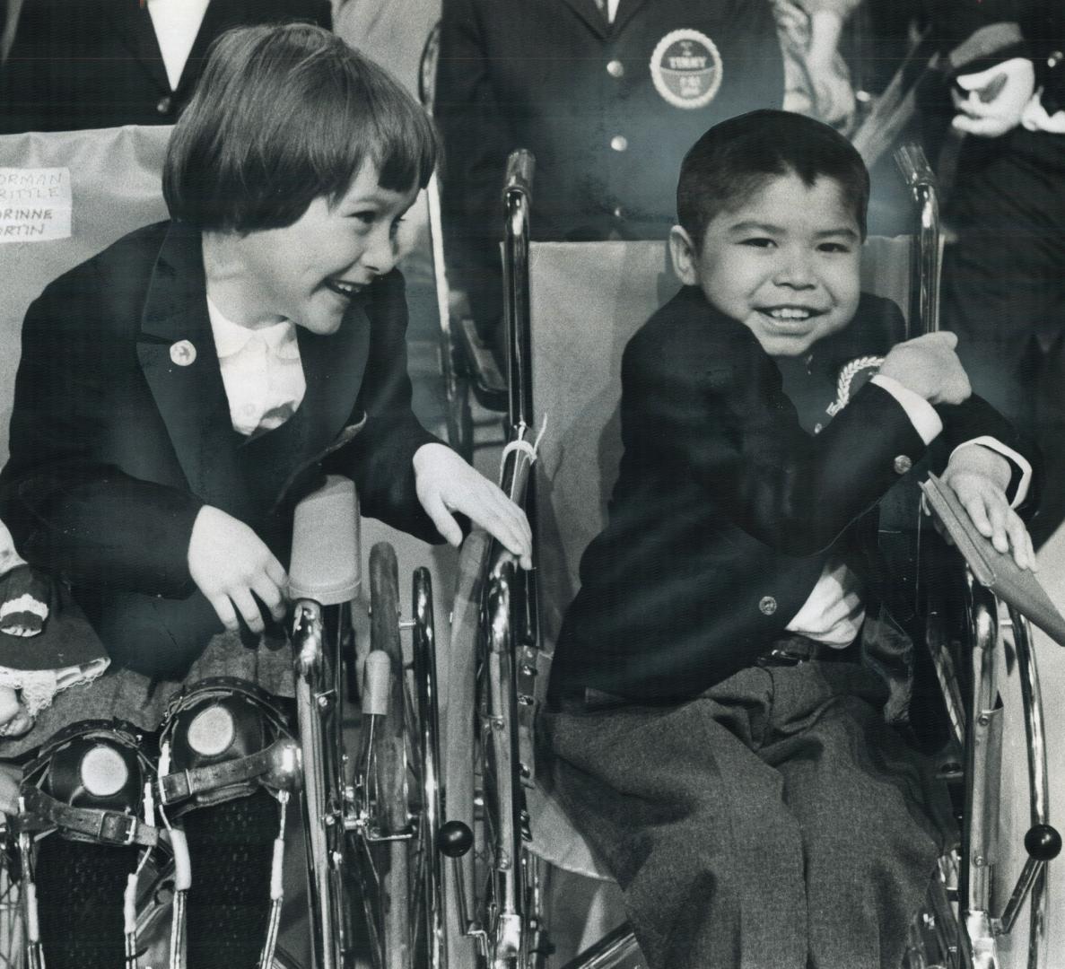 They're friends in need. In adjoining wheelchairs during their Toronto visit yesterday along with nine other Easter Seal Timmies and Tammies to launch(...)