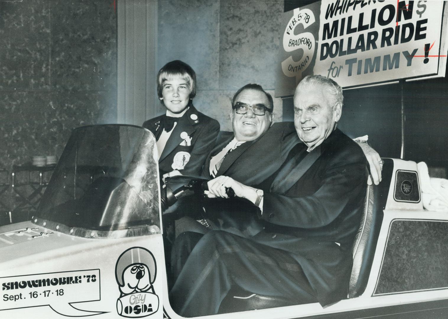 The Chief at the controls, Timmy-12-year-old Steven Fitzpatrick, and Whipper Billy Watson wheel into a dinner dance for the Ontario Society for Crippl(...)