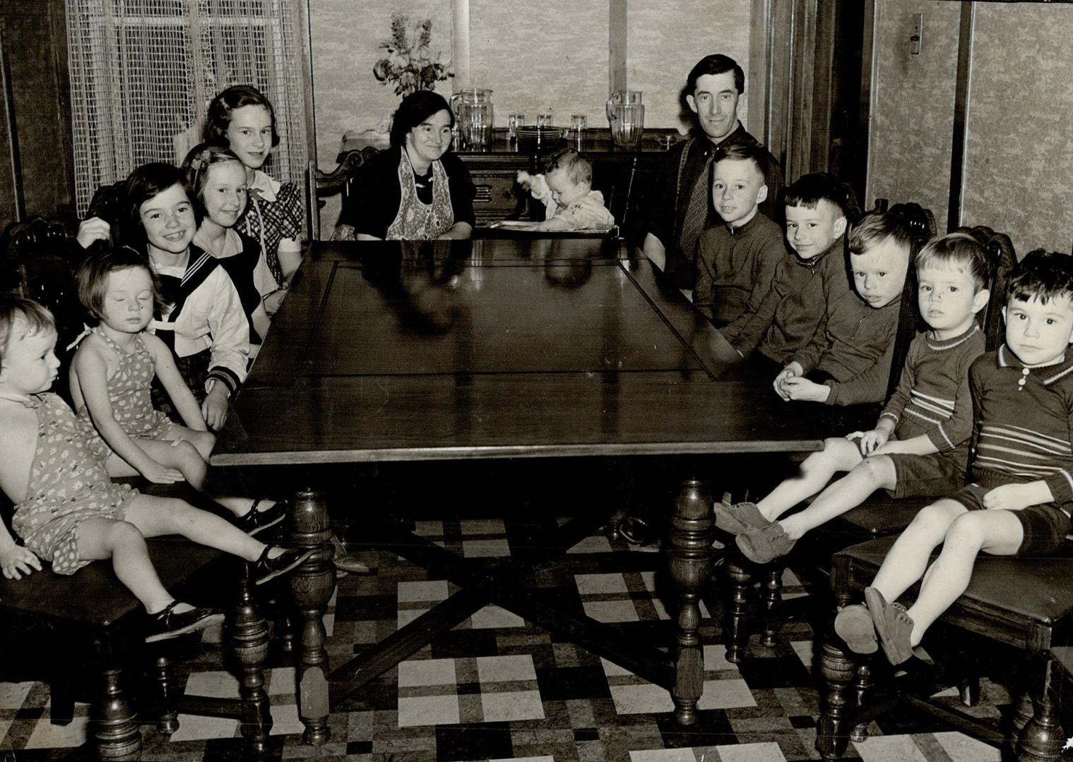 The Nagles At Home. There are 12 children in John Nagle's family. All of them are under 15. Their dining room table has to be the biggest obtainable