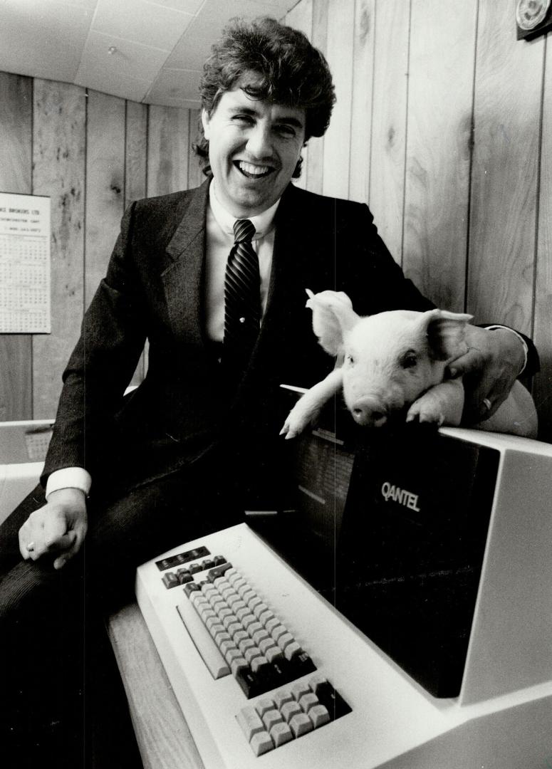 This little high-tech piggy...Jim Long, 30, holds one of the offspring produced by the Canadian Baconmaker operation, a program developed on his famil(...)