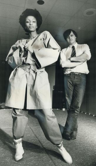 Paris designer Jean-Charles de Castelbajac watches a model wearing his beige linen tunic over red cotton pants