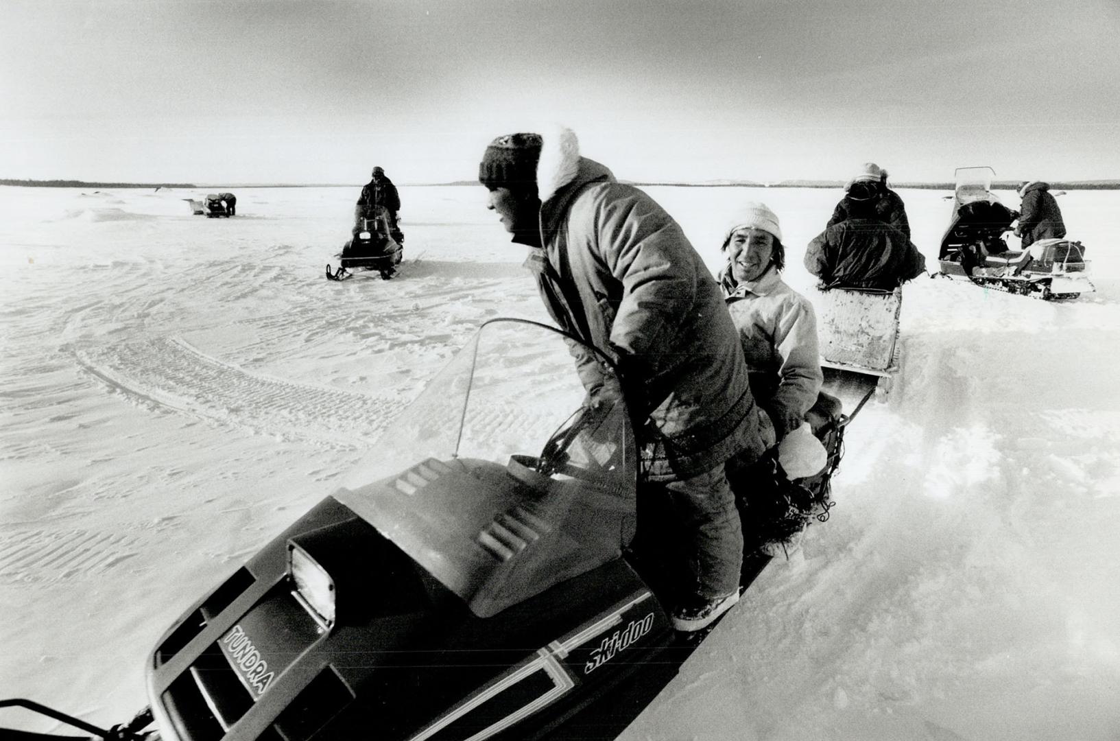 Sylvester Riche (left) and band chief Daniela Ashini set up a stove in their tent after heading out to a fishing camp (below)