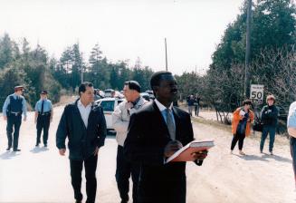 Judge Hugh Fraser, black, in suit, at Ipperwash shooting site