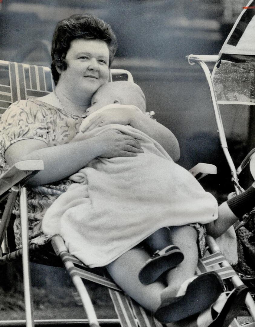 Mrs. Robert Huggett holds 2-year-old Michael and listens to lectures on the Bible, which went on from 10 a.m. to 5.30 p.m., with a two-hour lunch break