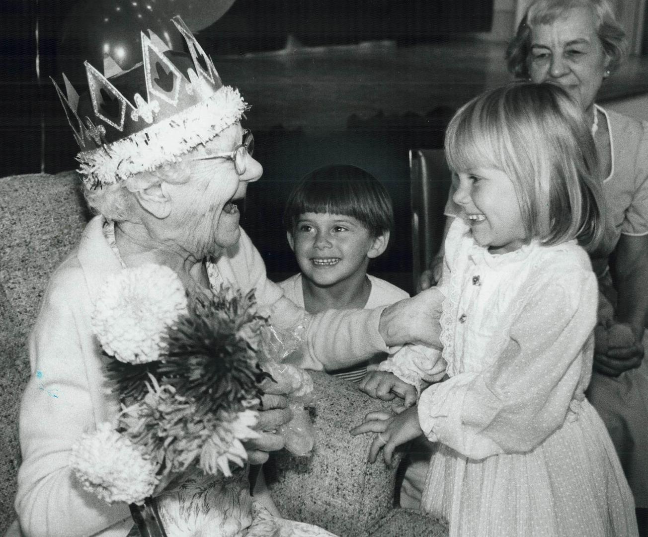 Happy 100th birthday, great-grandma!, Rebekah Bajari, 5 1/2, with help from brother Joshua, 3 1/2, presents a bouquet of freshly picked flowers to gre(...)