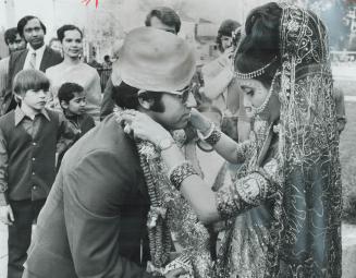 Wedding rites 5,000 years old, Jawahar Adhiya, who comes from Dahanu, India, meets his bride, Jasani of Bombay, outside the Hindu Temple on Indian Rd.(...)