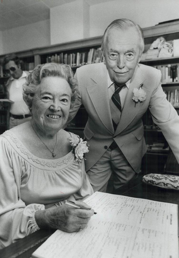 Lucky 77, Peggy Booth Signs the register as new husband Frank Robinson looks on after they married yesterday