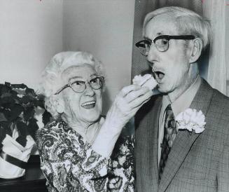 A piece of 60th wedding anniversary cake is fed to Lorne Barton by his wife, Edna, yesterday as a dozen neighbors joined the North York couple while t(...)