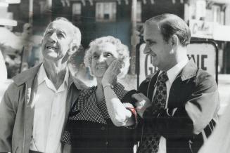 Surprise shows on 88-year-old Ann Laidlaw's face as she and her 89-year-old husband, Jim, view congratulatory sign rented by their family, at Danforth(...)