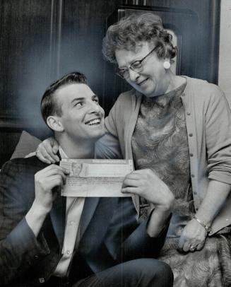 David Elliot shows his landlady, Mrs. J. H. MacKenzie, telegraph announcing he's won $26,000 Irish sweepstake prize when horse named Norton Priory fin(...)