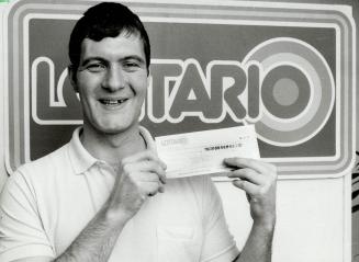 Bachelor wins $358,484 from lottery, Douglas Heughen, 28, laid off from his laborer's job with the City of Toronto, shows the cheque for his winnings (...)