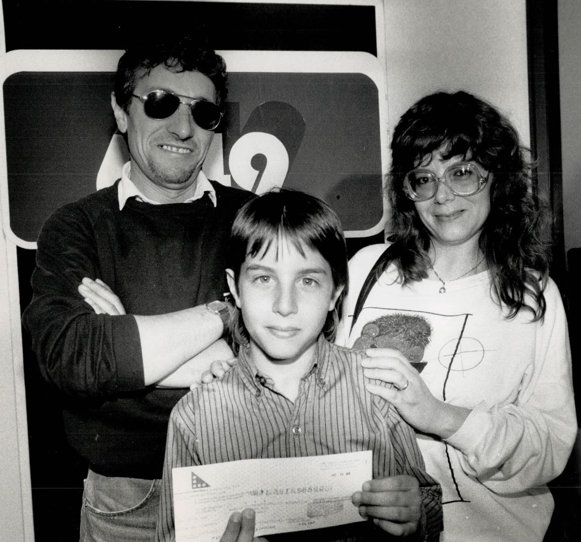 Family of instant millionaires, Emilio Sugamosto, left, son Christian and wife Maria hold a cheque for $3,415,958