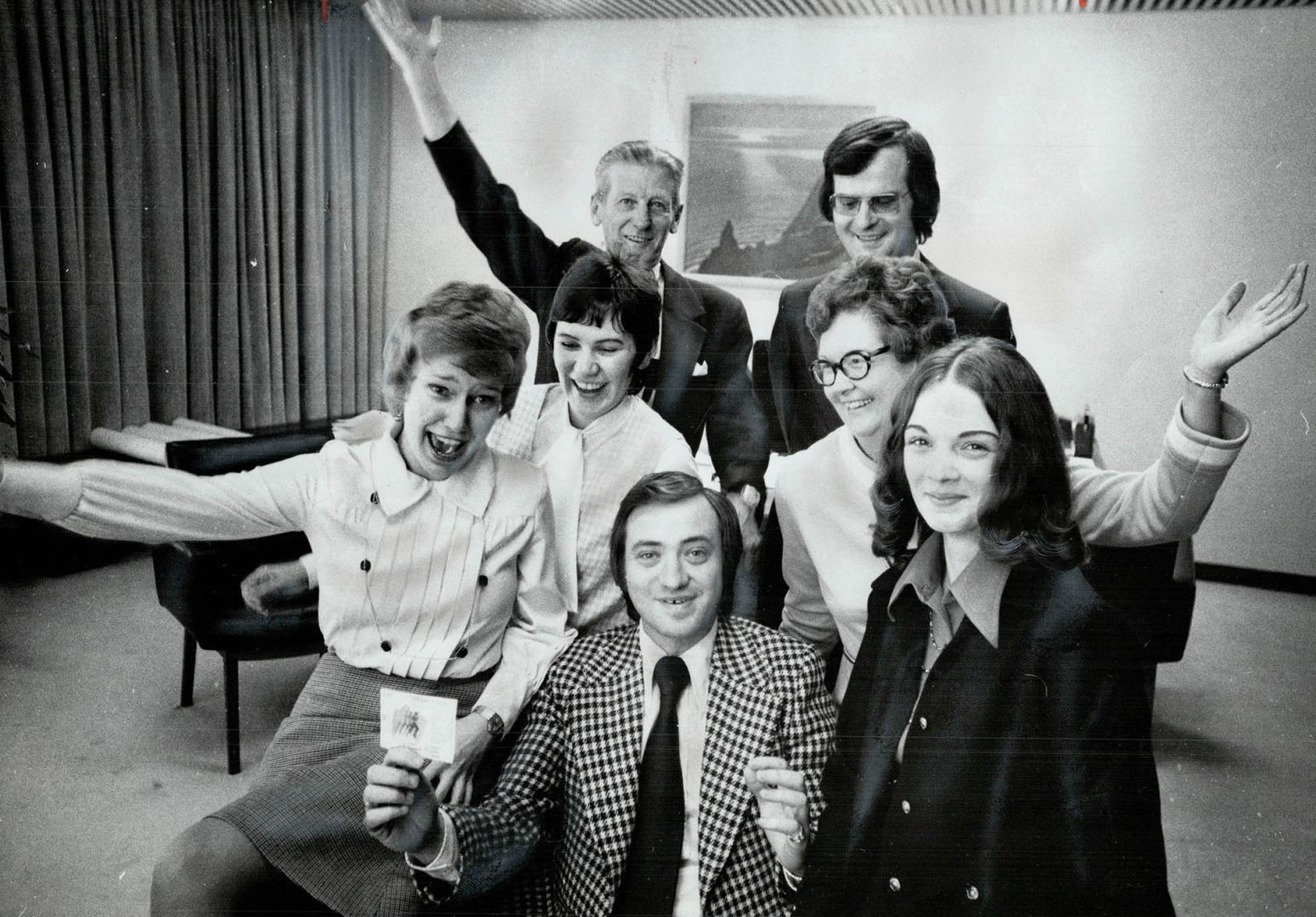 A $1,000 prize in the Olympic Lottery is shared by Metro Chairman Paul Godfrey (seated) and members of his staff