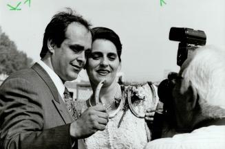 With this shoe: Willie Wilson and Lauren Wenstrom hold lucky horseshoes after tying the knot at Woodbine yesterday