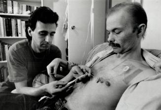 François Dansereau, 34, left, helps Andrew Welch, 32, take his daily dose of ganciciovir, administered through his chest. Welch, who was diagnosed wit(...)