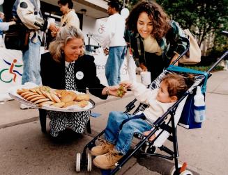 C is for cookie - and caring, Rita Mabrucco offers treats to Victoria Martinez, 20 months, and mom Zaide Mendoza during National Coffee Break Day in a(...)