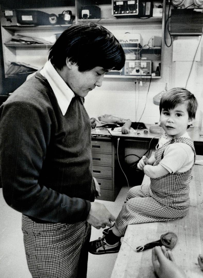 Anticipation: Paul sits ready for a new life as technician Rinchen Dakpa prepares to fit the left arm the child has had missing since birth