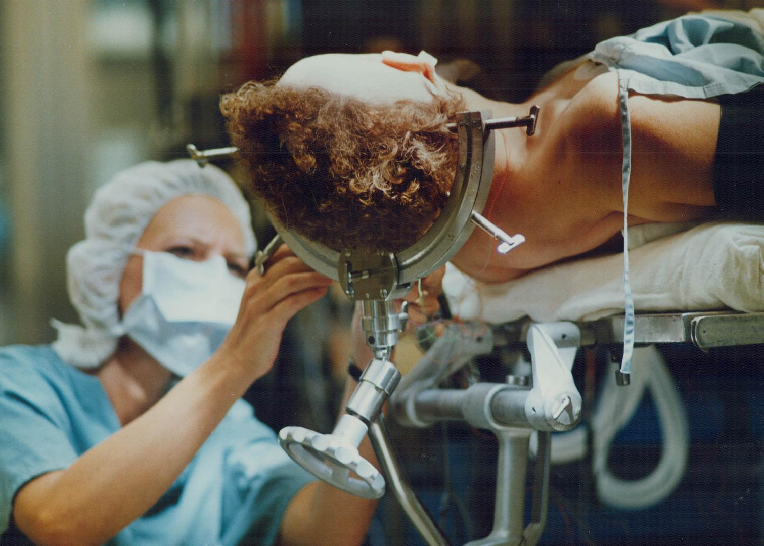 Technologist Vera Mraz monitors the patient's brain waves during surgery to see if anything is going wrong