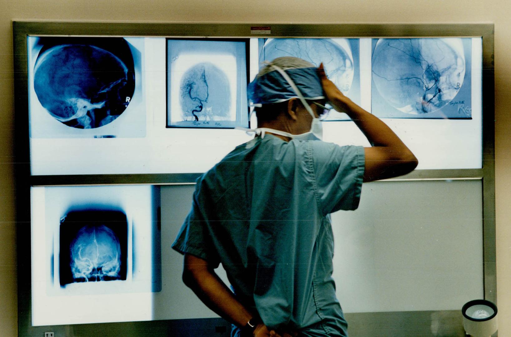 A doctor reviews x-rays of the patient's brain