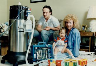 Marks and Kelly Bakker take time out from constant care to play with son Jordan 2 1/2, attached to an oxygen tank because he suffers from bronchial pulmonary dysplasia, a respiratory complication