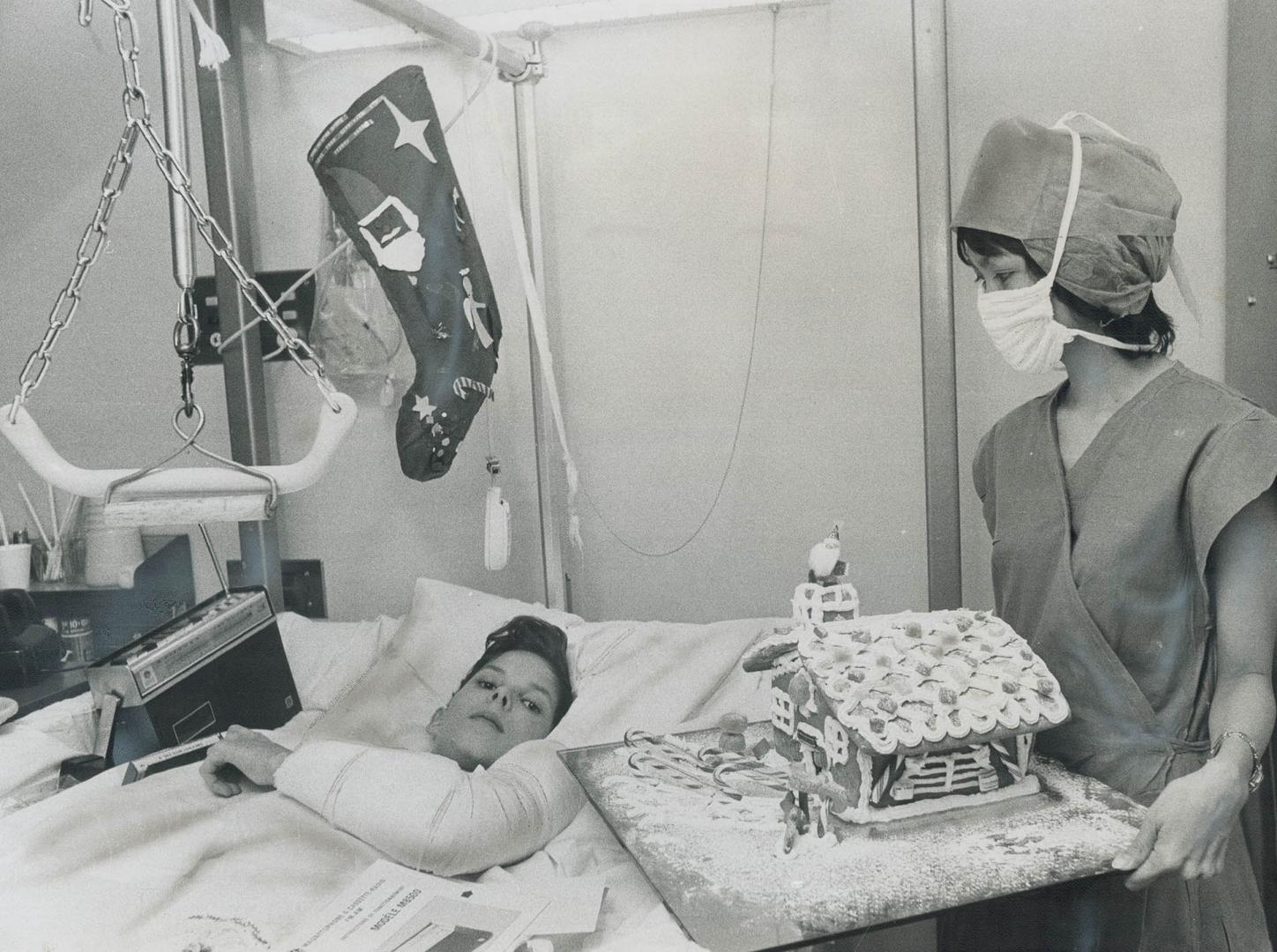 This Santa wears a surgical mask, Clad in surgical gown and mask, nurse Harmonia Pascual hands Cameron Smith his Christmas presents at Scarborough Gen(...)