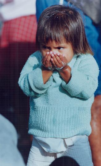 Peru - Young girl drinking water at well outside Lima