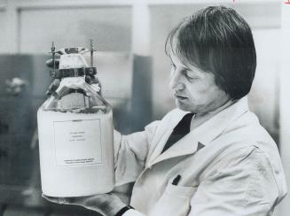 Research associate Nikola Cucakovich holds up a bottle of swine flu vaccine concentrate that will be used to make 250,000 shots