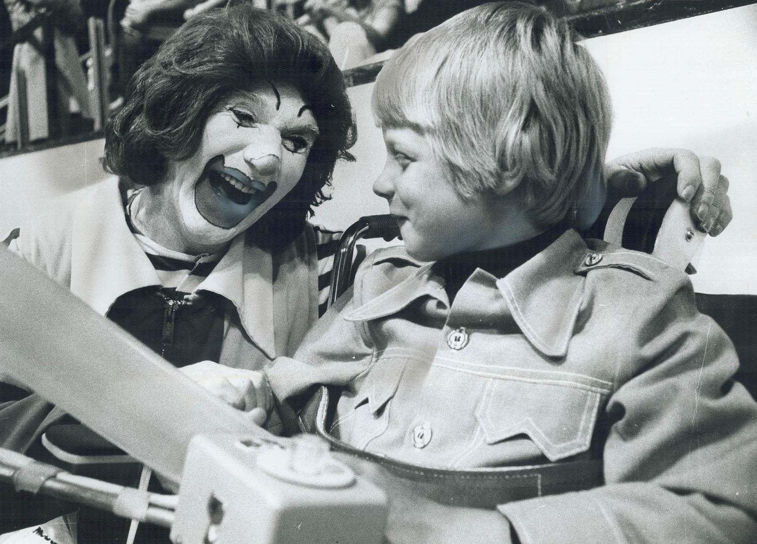 Muscular dystrophy victim Vincent Nadeau, 10, jokes with Ronald McDonald the Clown at Varsity Arena party