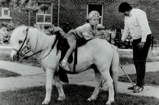 Heading the wrong way, Photographer Gord Oswald of Janitis Studio in Scarborough uses his pony as a prop while taking pictures of youngsters around me(...)