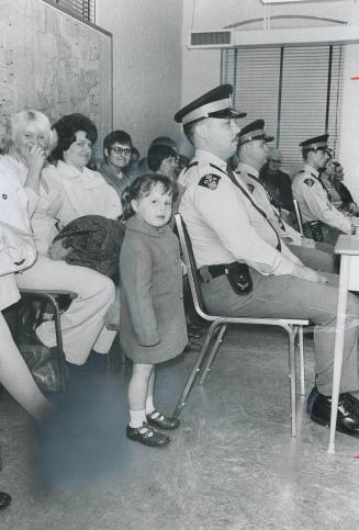 A pat on the back for dad, Sara-Ann Howells, 3, pats her father, Montsoyn, one of 45 policemen who graduated yesterday from Ontario Provincial Police (...)