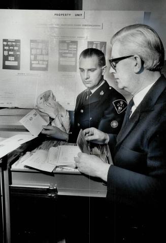 The search: Corporal G. H. Bradeley and Charles O'Byrne of OPP check a cleaner's mark