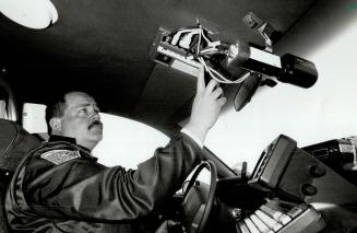 Say Cheese: Peel Region traffic division Constable Ed Spence operates a control panel for one of the force's 11 new $7,500 video camera units that are mounted on the police cruiser dashboard