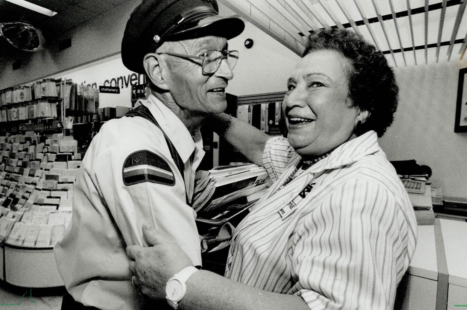 Retiring letter carrier John Hoggett gets a hug from shoppers Drug Mart employee Evelyne Rozelu