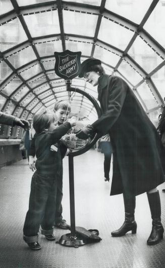 God bless the little children, Cadet Susan Hornsby accepts a donation from these two youngsters at her Salvation Army post in the walkway between Simp(...)