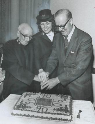 Celebrating the 90th anniversary of the Salvation Army in Canada, an elaborate cake is cut by Lt