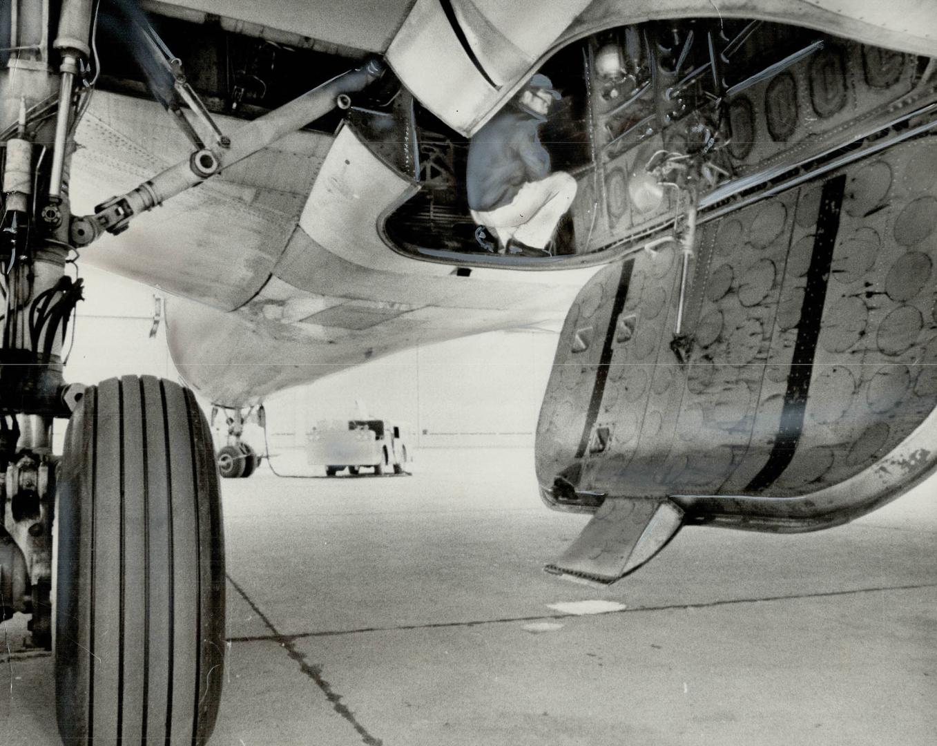 Here's how Cuban Hitched 5,000-Mile Jet Ride to Freedom Technicians huddles in Air Canada DC-8 to show how Cuban stowed away in Spainsh jet's undercarriage