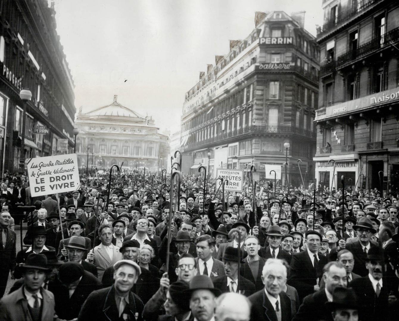 Demonstrating for higher pensions to meet the increased cost of living, disabled French veterans, most of them amputation cases, raise their canes hig(...)