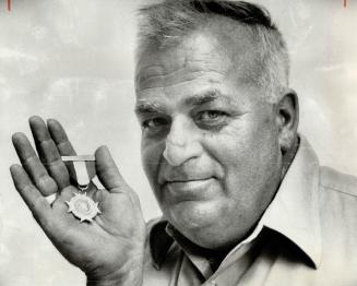 Dieppe Veteran Bill Stevens displays the special medal struck by the city of Longueuil, Que