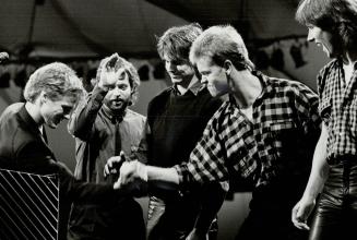 All-right! Bryan Adams (far left) and his band join hands for a victory cheer at last night's Juno Awards ceremonies