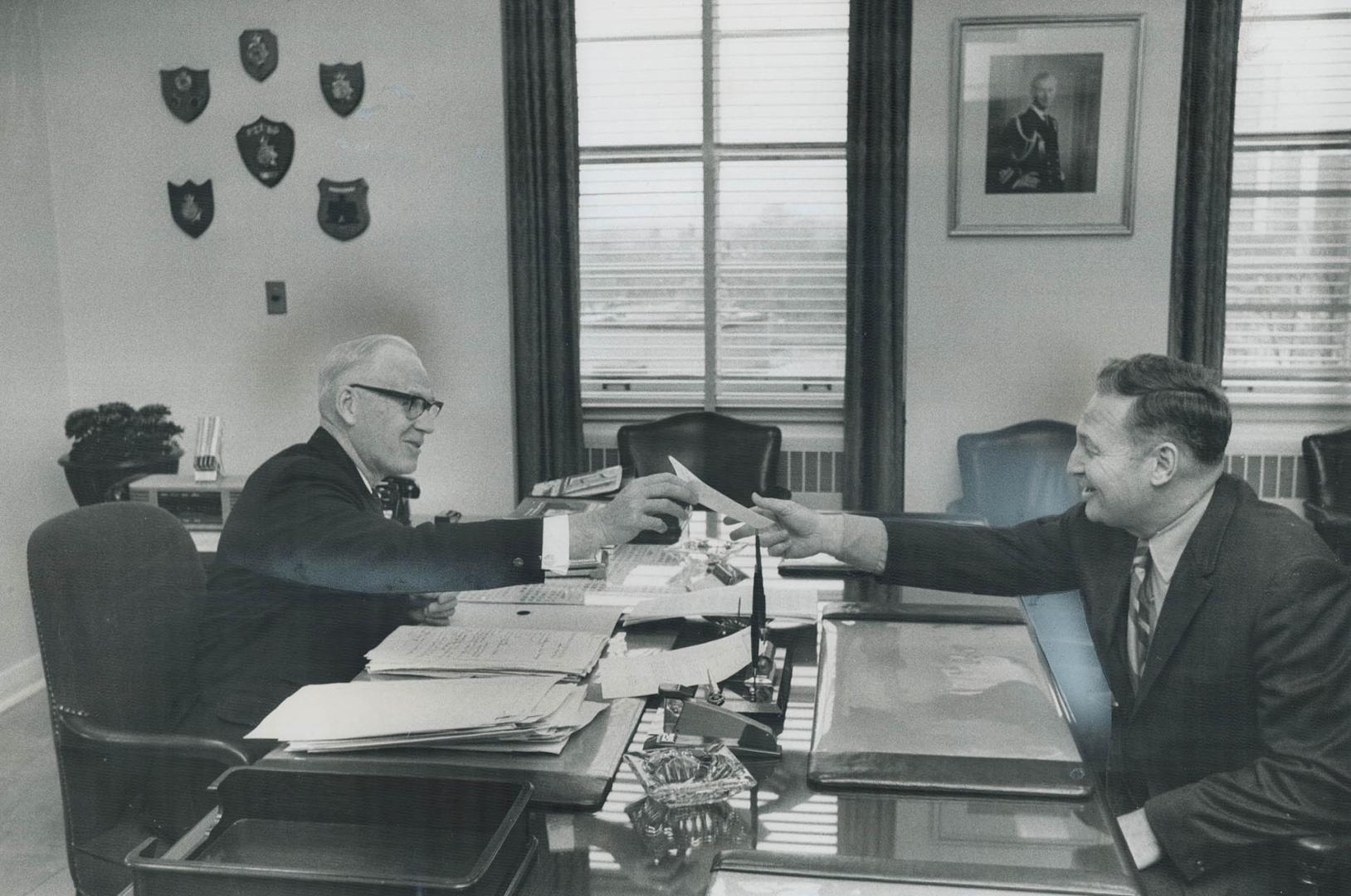 Toronto's new police chief takes over, At his desk for the last time today, Toronto's retiring police chief James Mackey (left) smiles as he hands pap(...)